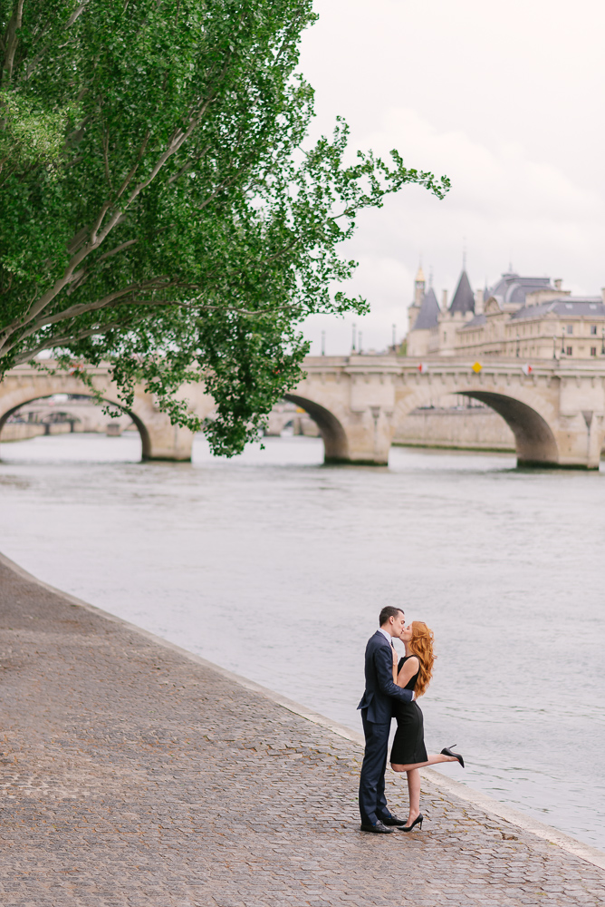 Couple kissing on the river bank in an European city