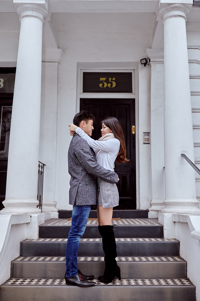 Asian couple posing for modern engagement pictures in London in front of London appartment building