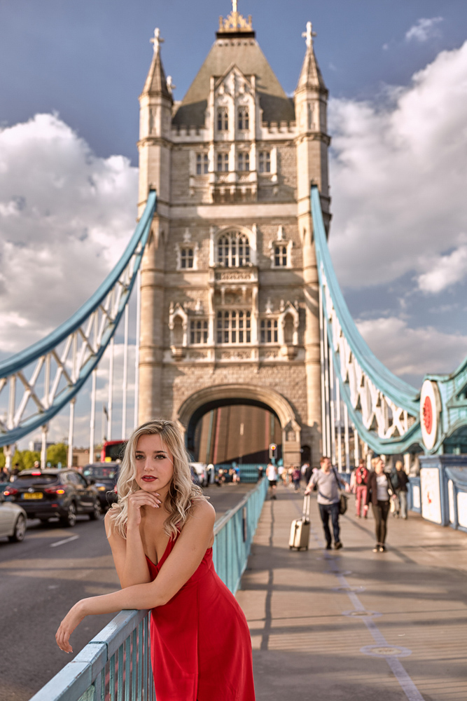 Beautiful blode girl in red dress smiling in front of camera on her birthday photo session in London
