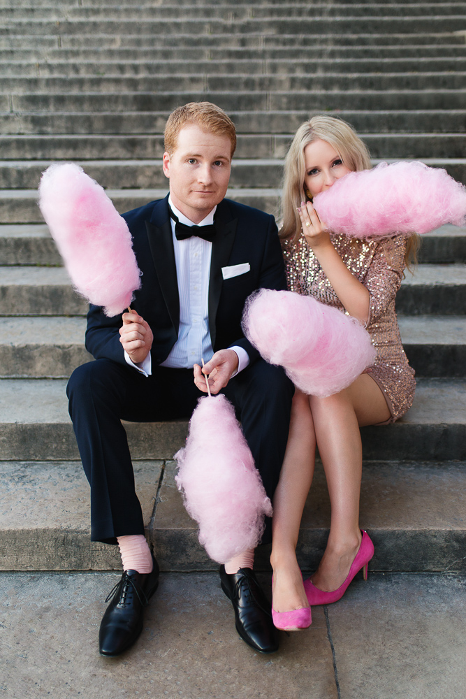 Fun engagement picture of a stylish couple eating pink candy floss or cotton candy