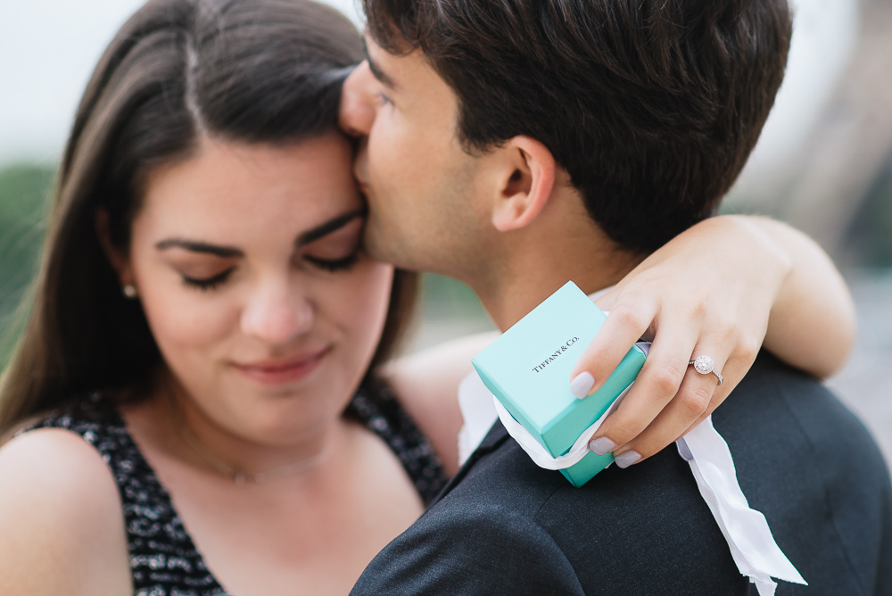 Newly engaged couple posing for pictures with Tiffany & Co ring box in hand