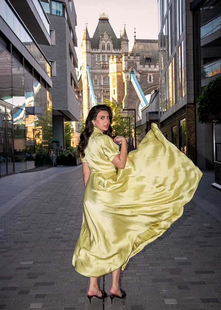 Beautiful woman flicking yellow dress for effect during a portraits photoshoot in London with Tom