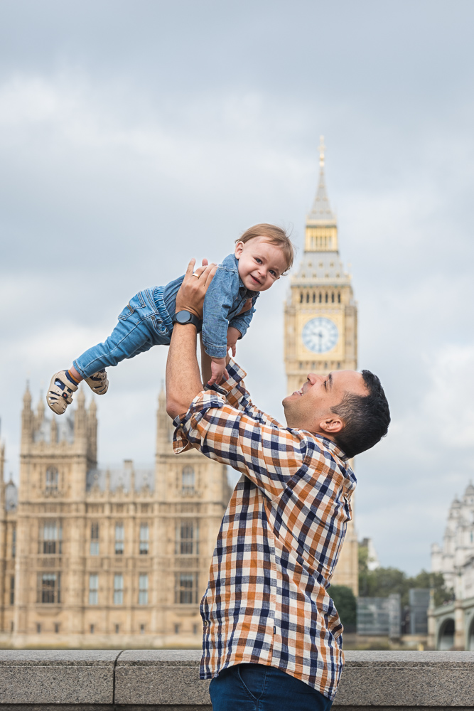 Father throwing kid up in a playful manner in front of Big Ben