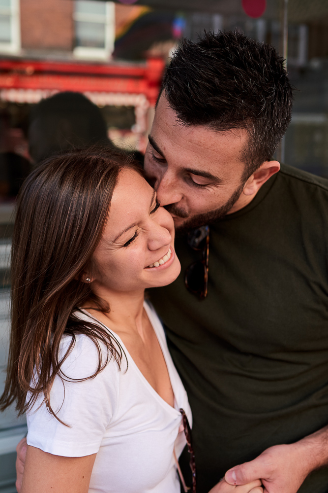 Man kissing his fiancée on the forehead while she is smiling
