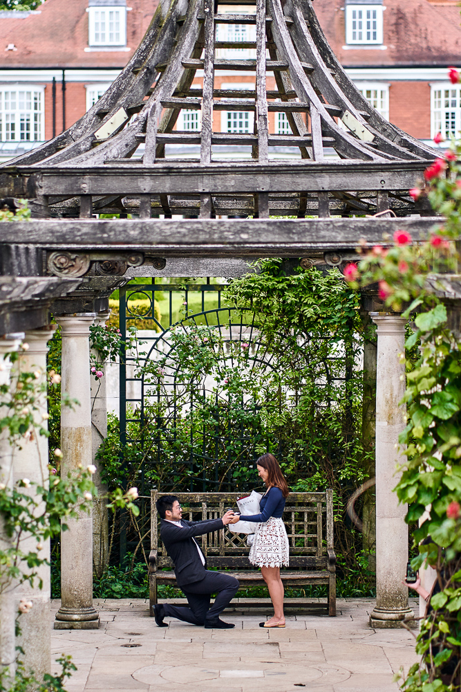 Man on a knee proposing to his girlfriend in a garden in London