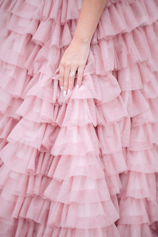 Mother holding hand with diamond ring on gorgeous long tulle pink dress