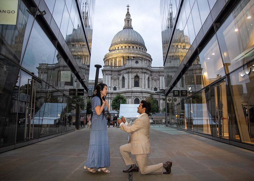 The moment of a surprise marriage proposal captured by a talented proposal photographer in front of Saint Patrick's cathedral in London