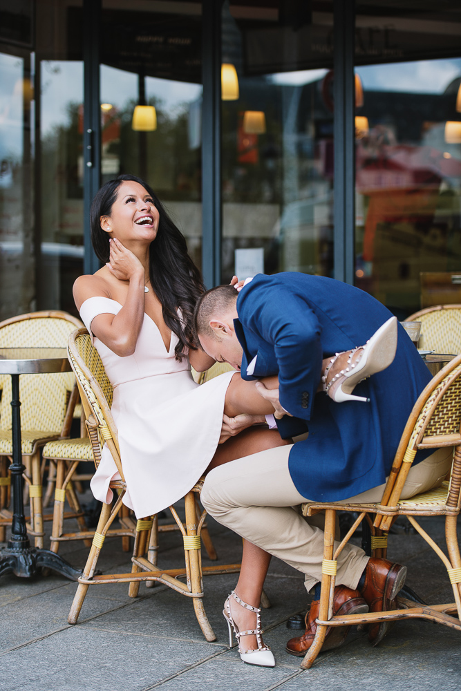 Fun engagement photo of a couple sitting in a café and having fun