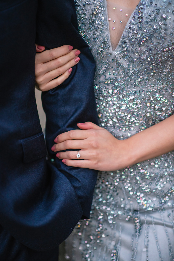 Details of bride holding the arm of her groom