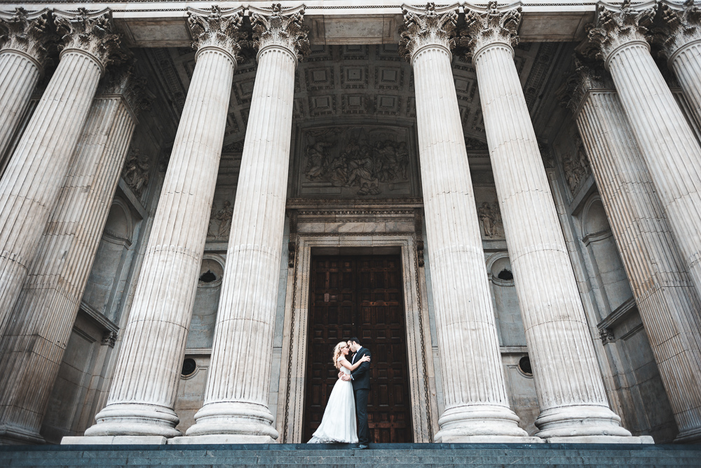 Bride and groom kissing in front of St. Paul's Cathedral in London