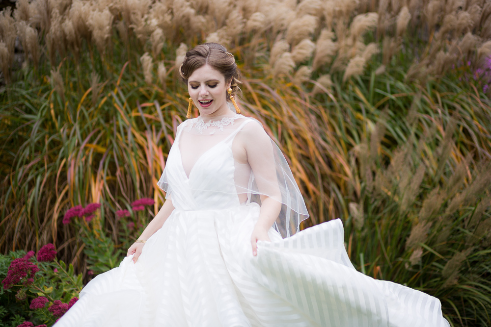 Bride happily posing in a field for her elopement photoshoot