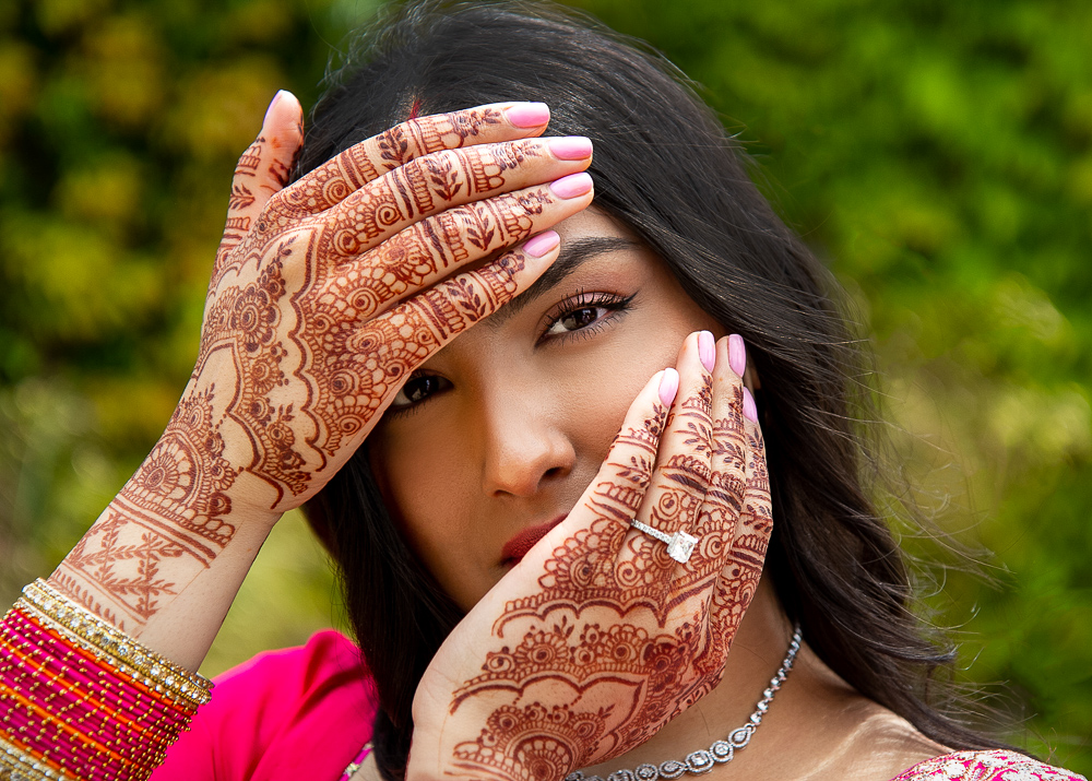 Girl with hena on hands wearing a diamond ring is posing for engagement photos in London