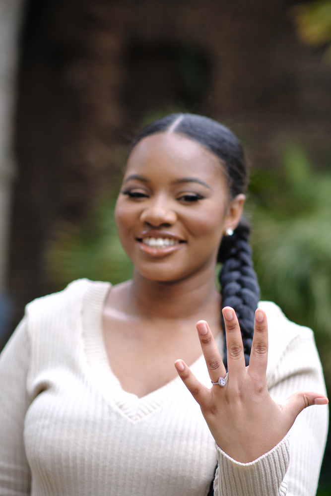 Happy woman smiling and showing engagement ring in the moment right after her marriage proposal