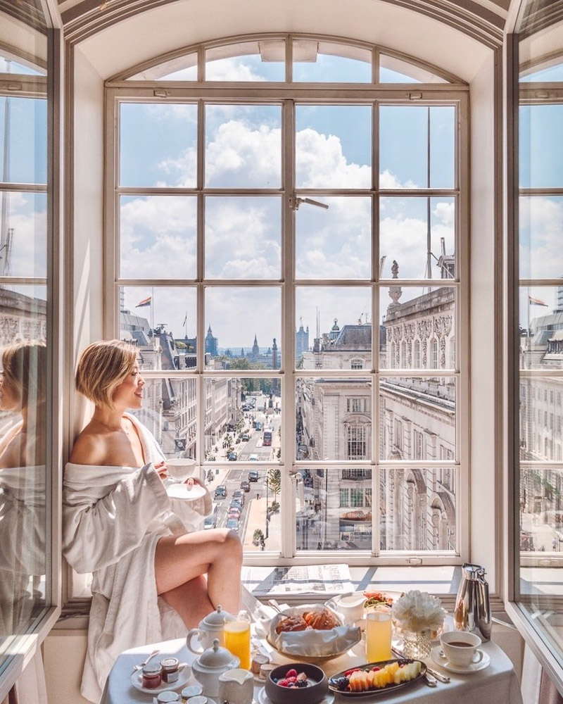 Girl taking her breakfast by the window of Hotel Cafe Royal
