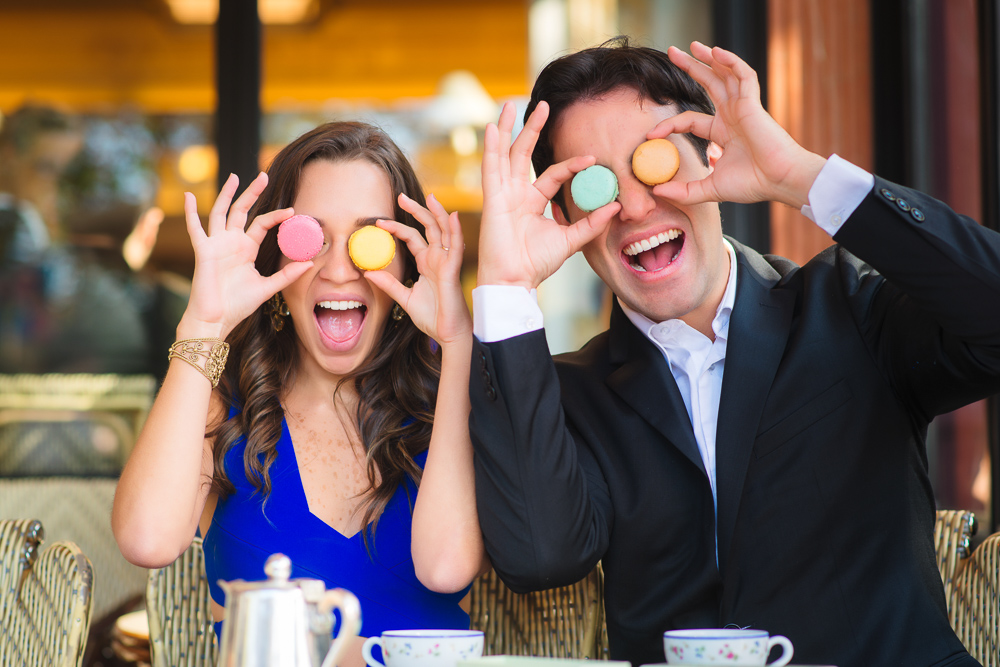 Couple having fun with macarons during a photo shoot with The Now Time