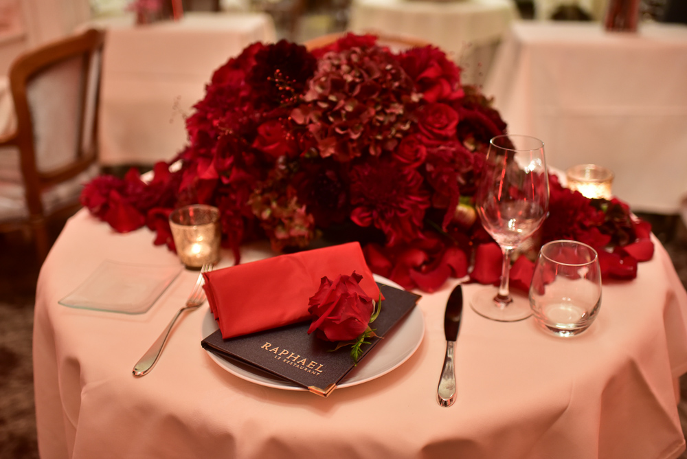 Romantic dinner setup with red roses before marriage proposal