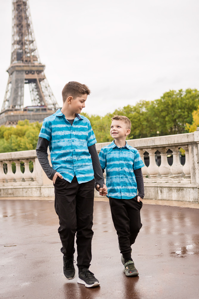 Two brothers walking hand in hand by the Eiffel Tower in Paris