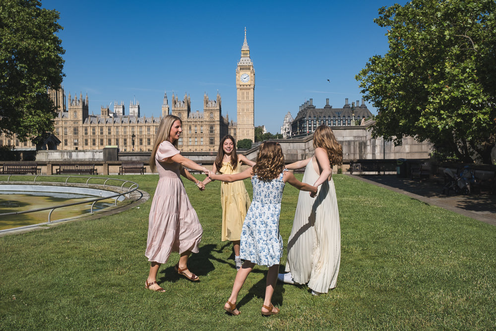 Mother and 3 daughters dancing during a family photo shoot in London