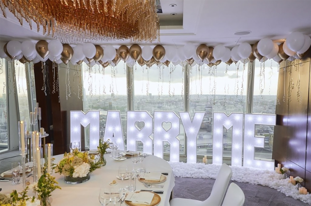 Romantic marriage proposal setup with MARRY me sign