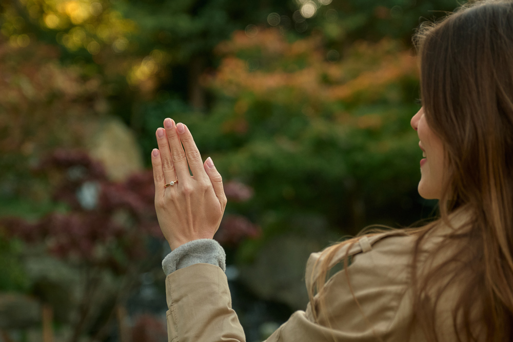 Young woman looking at her engagement ring right after getting engaged in a park in London