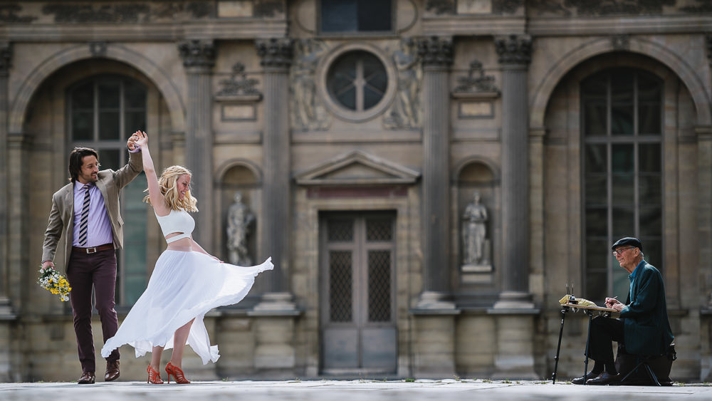 Couple dancing in front of an artist in the streets of a European Capital