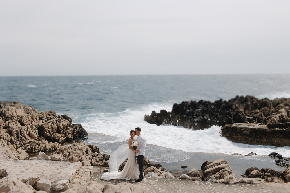 Wedding Photographer on the French Riviera - Bride and groom posing for photos on the rocks in Cannes