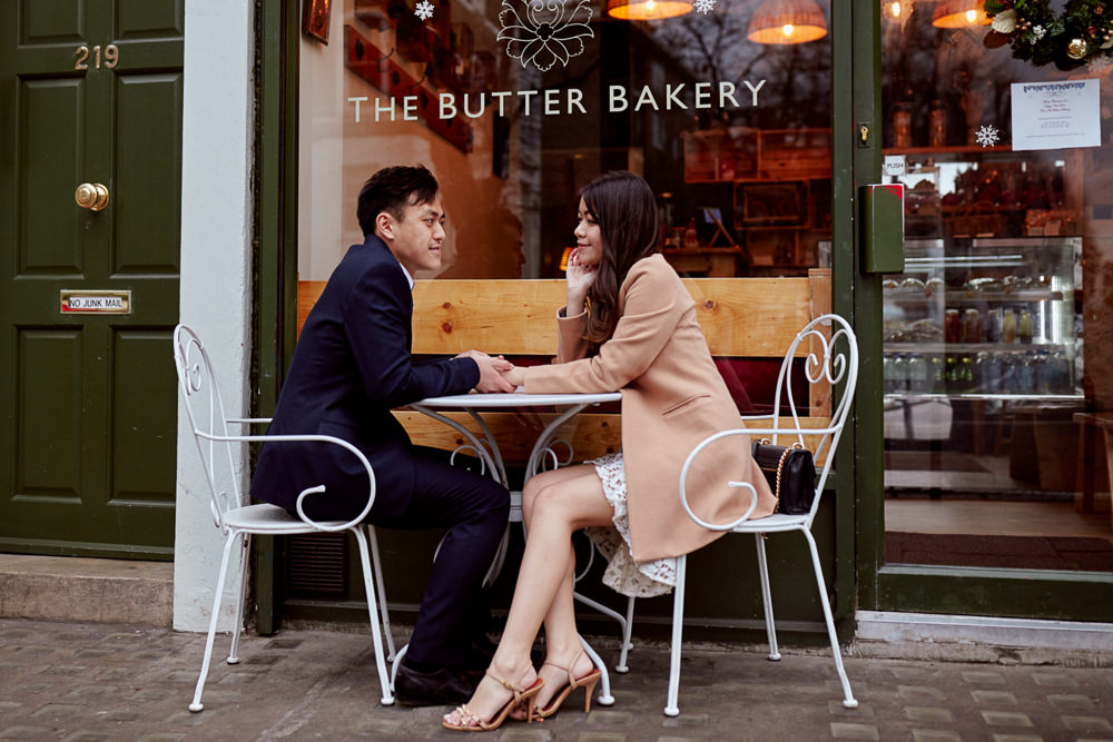 Couples poses holding hands across the table