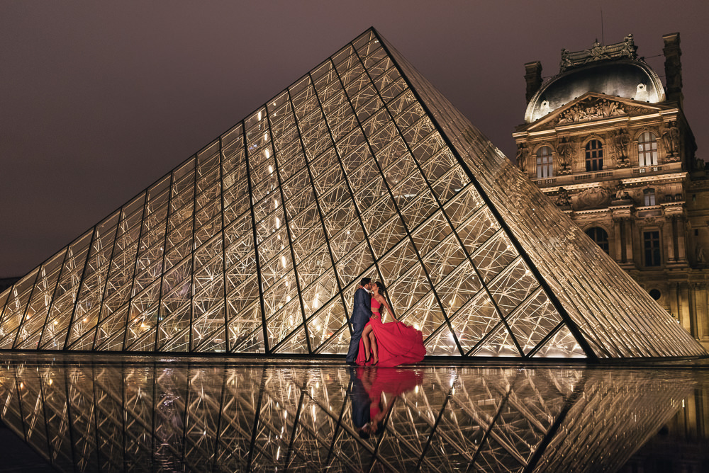 Elegant couple kissing during night engagement photoshoot