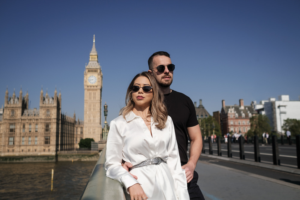 Young couple wearing sunglasses posing for romantic couples photos in front of Big Ben in London