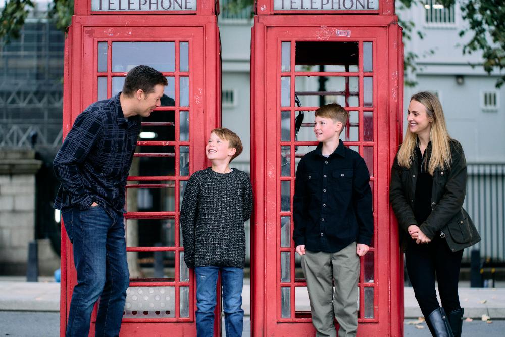 Couple with kids having fun near iconic London phone booths